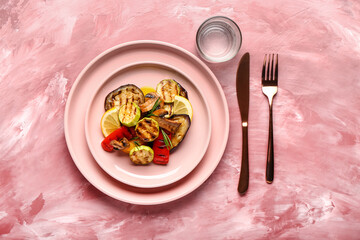 Plate with tasty grilled vegetables on color background