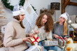 © ako-photography - young girls having fun wrapping gifts at home, great teamwork of friends packing presents for christmas