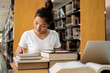 © Orathai - Young Asian women are searching for books and reading books on the tables and aisles of the college libraries to research and develop their academic and education self