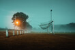 © Hofschulz & Schoppa - Neblige Stimmung an der Torlinie auf dem Fußballfeld am Abend mit erleuchteten Straßenlaternen auf dem Dorf
