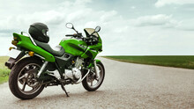Green Motorcycle Stands On A Rural Road