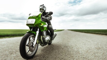 Motorcyclist Rides A Green Motorcycle On A Country Road