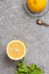 Wall Mural - Half a juicy lemon with mint leaves and sugar in a bowl on the kitchen table