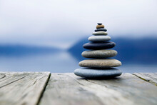 Zen Balancing Pebbles Next To A Misty Lake.