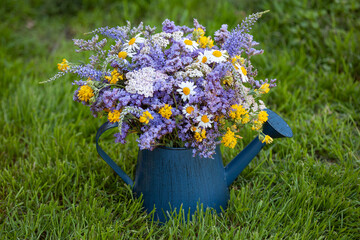 Wild flowers in a blue metal watering can