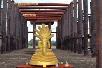 Sticker - A never finished and abandoned Thai temple with a golden Buddha statue