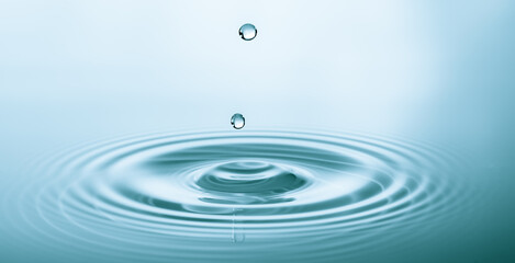 Wall Mural - splash of water droplets on a smooth water surface