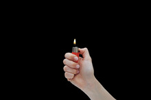 Hand With Red Lit Lighter Isolated On Black Background. Concept Hands And Fire