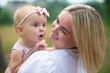 © Светлана Лазаренко - Happy woman looks at her daughter. Mom with a one-year-old child.
