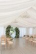 The wedding arch is decorated with flowers. White Tent