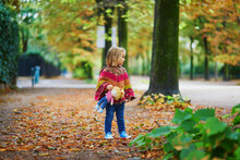 Adorable Toddler Girl Walking In Park On A Fall Day In Paris, France