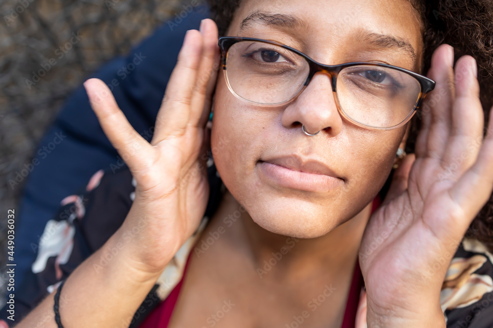 African American woman with long curly hair and glasses is happy and ...