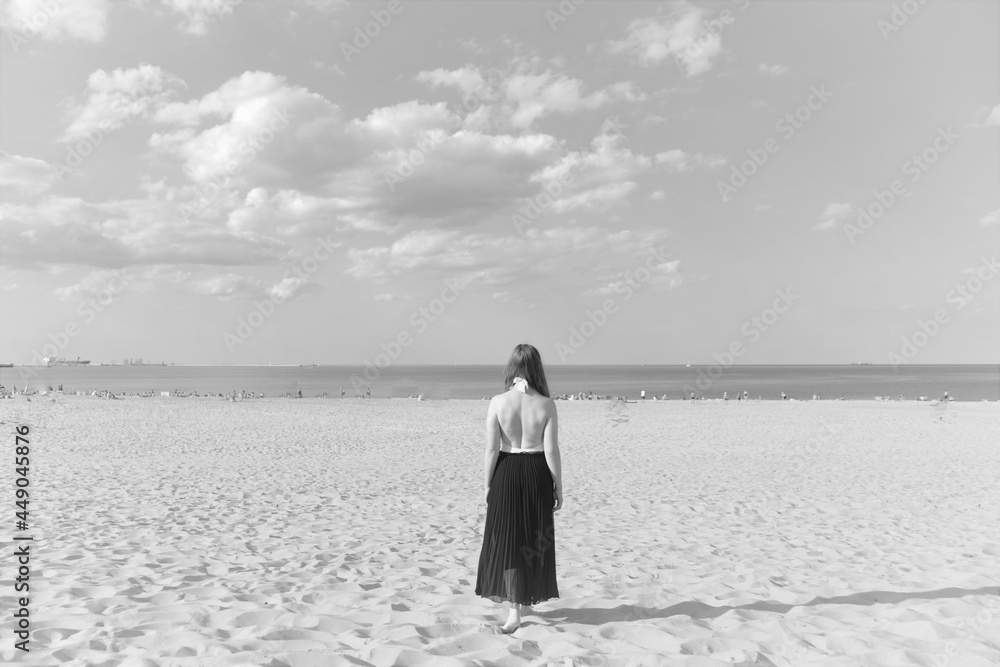Stojąca tyłem kobieta na plaży  - obrazy, fototapety, plakaty 