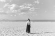 Stojąca tyłem kobieta na plaży 