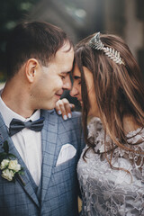 Wall Mural - Beautiful emotional wedding couple laughing and hugging in european city. Provence wedding. Stylish happy bride and groom smiling and embracing on background of old church