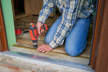 Man Is Making A Threshold On The Floor,Installation Of Self-adhesive Threshold When Docking Floor Coverings