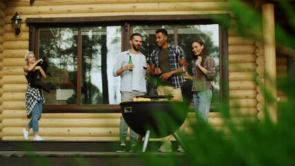 Wall Mural - Relaxed friends cooking vegetables on grill on backyard. Woman taking dog