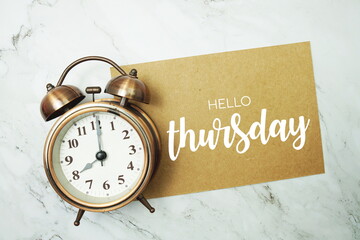Wall Mural - hello thursday typography text on paper card with alarm clock on marble background