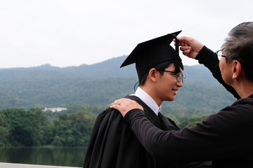 Wall Mural - Student with congratulations, graduates wearing a graduation gown of university.