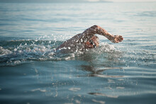A Sports Man Is Engaged In Swimming On The Sea. Swims Crawl Across The Ocean At Dawn