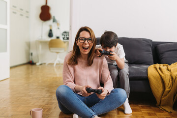 Wall Mural - mother and son playing video games at home