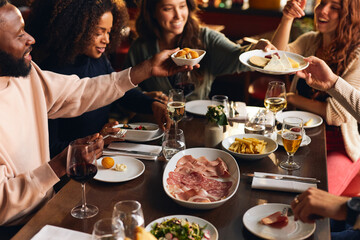 Friends sharing plates of food in restaurant