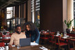 © Southworks - Small business owners using laptop in restaurant