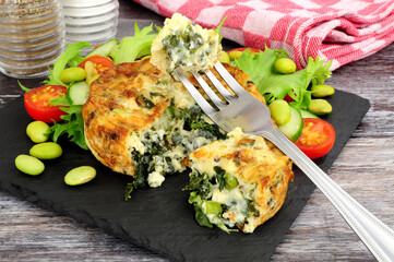 Wall Mural - Spinach and kale quiche with fresh salad and edamame beans on a slate serving board