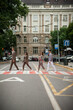 © alipko - Four young students under umbrellas in the city