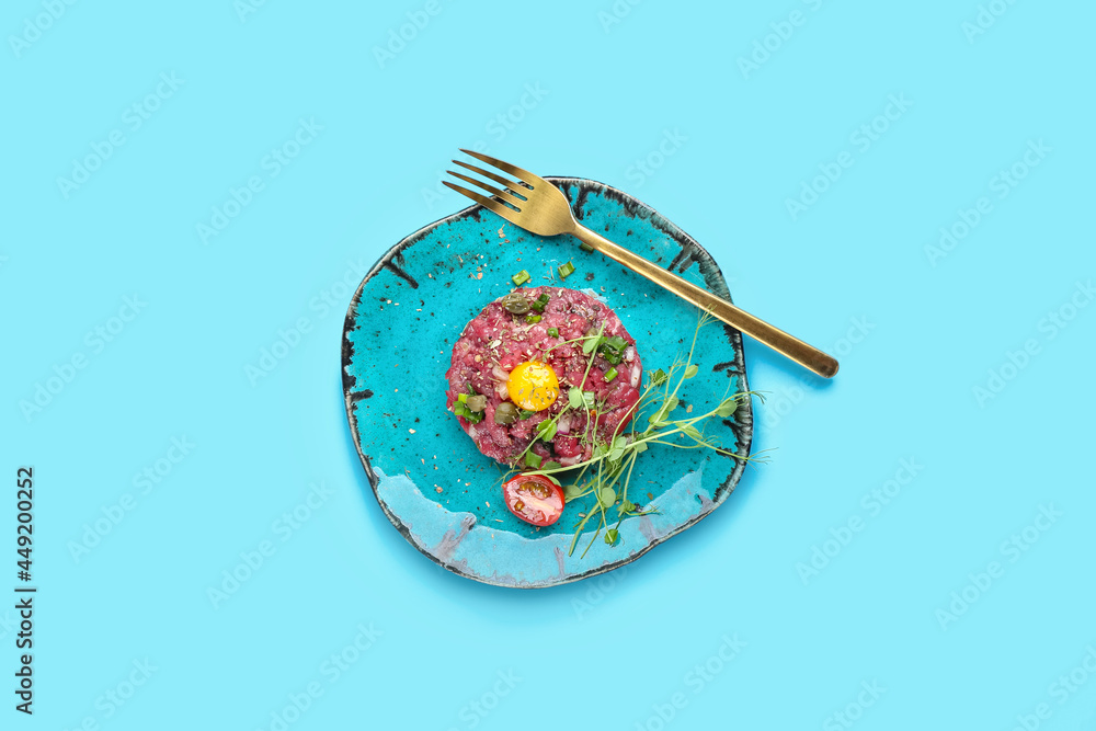Plate with tasty beef tartare on color background