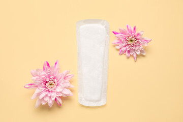 Menstrual pad and flowers on color background