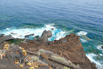 Wall Mural - Rocky coast of El Hierro and the blue Atlantic Ocean on a cloudy day