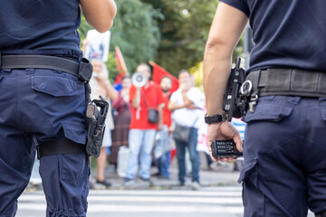 Wall Mural - Police officers on duty during street protest, blurred protester in the background
