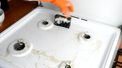 Poster - A man cleans a gas stove with a chemical cleaner