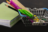 Fototapeta Tęcza - School supplies in the basket and a stack of notebooks