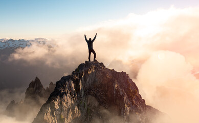 Wall Mural - Adventure Composite. Adventurous Man with Open Hands is taking in the moment on top of a mountain. Colorful Sunset or Sunrise Sky. Aerial Background Landscape from British Columbia, Canada.