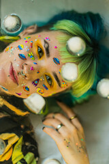 Wall Mural - Closeup fashion portrait young pretty beautiful girl with green and blue hair. Beautiful fashion girl with luxury professional makeup and funny emoji stickers glued on the face. Young woman