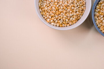 Poster - Top view of corn grains on bowls isolated on a light brown background