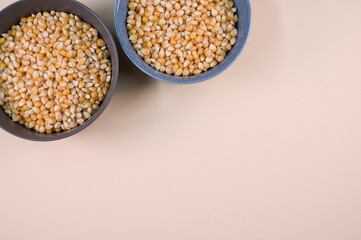 Poster - Top view of corn grains on bowls isolated on a light brown background