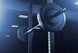 A barbell for training an athlete in the gym. Dark background.