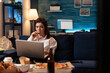 © DC Studio - Woman eating tasty snack working on laptop computer while watching documentary movie series on television. Caucasian female enjoying takeaway food home delivered. Fastfood delicious order
