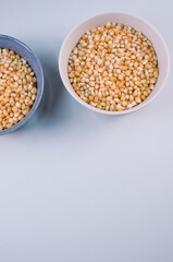 Sticker - Vertical shot of corn grains on bowls isolated on light gray background