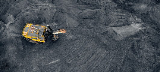 Wall Mural - Big yellow Excavator loads coal anthracite for in open mine, banner aerial top view