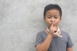 Boy with finger on lips No sound silent gesture Secret