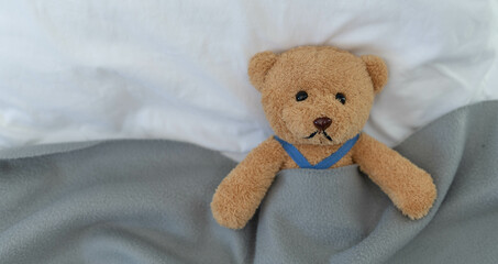 Wall Mural - A sad teddy bear lies sick in bed with disappointment and discouragement