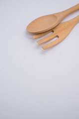 Canvas Print - Vertical shot of wooden fork and spoon isolated on light gray background