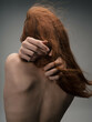woman with bare shoulders posing red hair isolated background