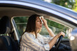 © DimaBerlin - Girl driver being hot during heat wave in car, suffering from hot weather, has problem with a non-working air conditioner, wipes sweat from her face with tissue. Summer, heat concept.
