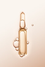 Ampule With Serum And Bubbles Around On Cream-coloured Background.