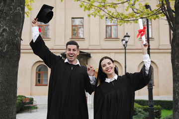 Poster - Happy students with diplomas after graduation ceremony outdoors